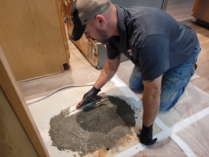 Plumber performing slab leak repair in Marietta, GA by repouring concrete after fixing underground pipe damage.