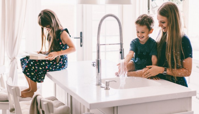 Family In Kitchen With Water Running Family In Kitchen With Water Running