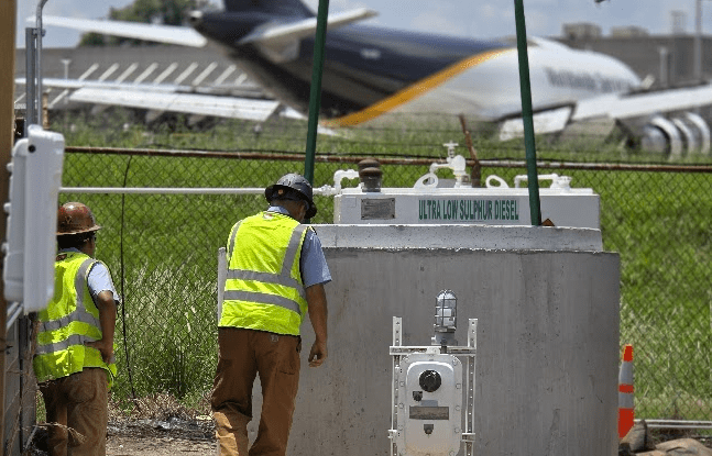 Technicians inspecting a commercial lift station near an airport facility